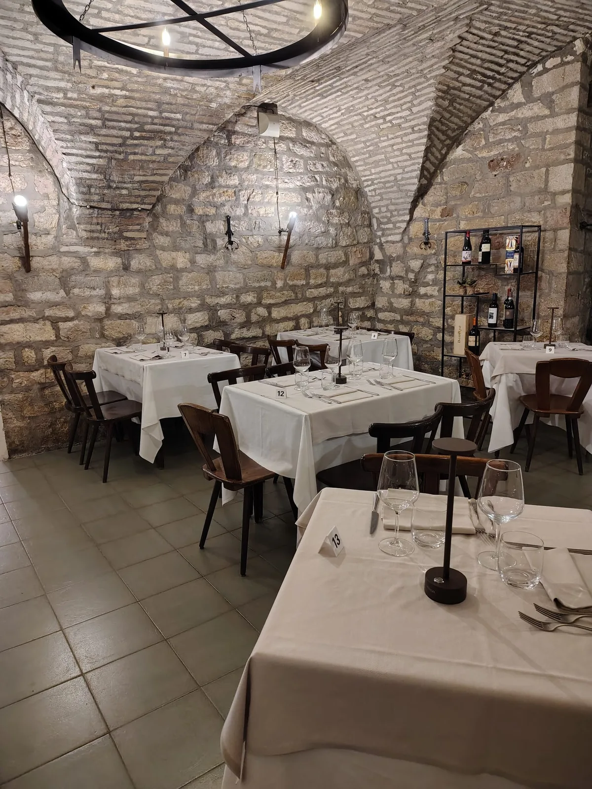 Sala interna della Grotta dei Priori sotto le volte in pietra, tavoli apparecchiati