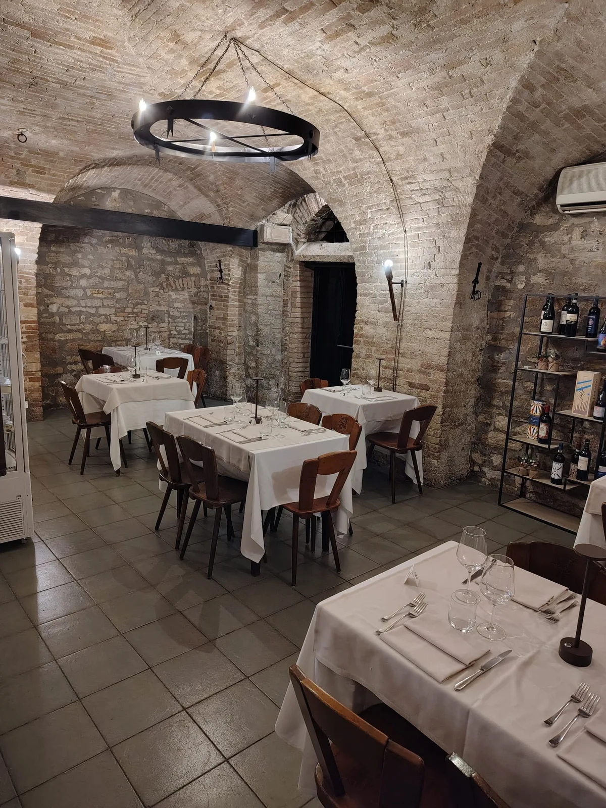 Sala della Grotta dei Priori con lampadario circolare e volte in mattoni