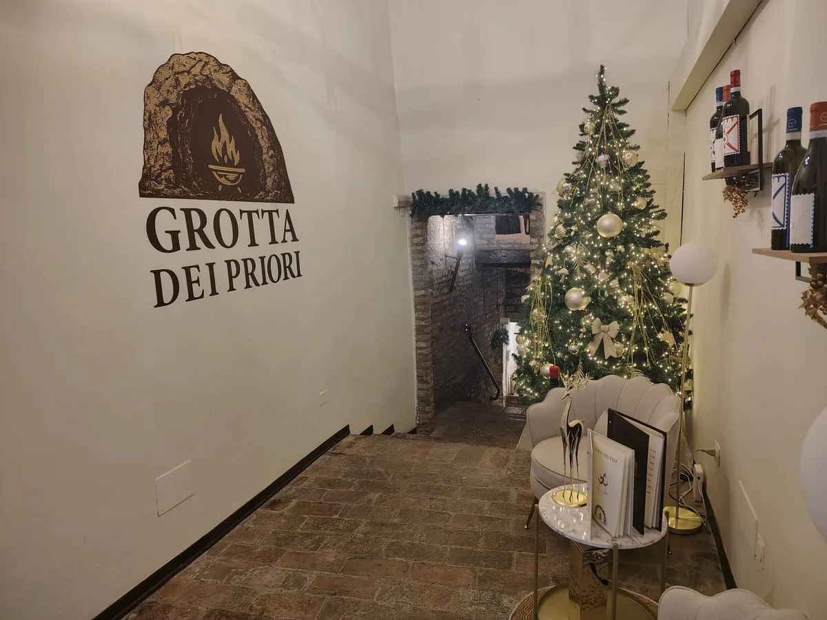 Ingresso invernale della Grotta dei Priori con albero di Natale e logo sul muro