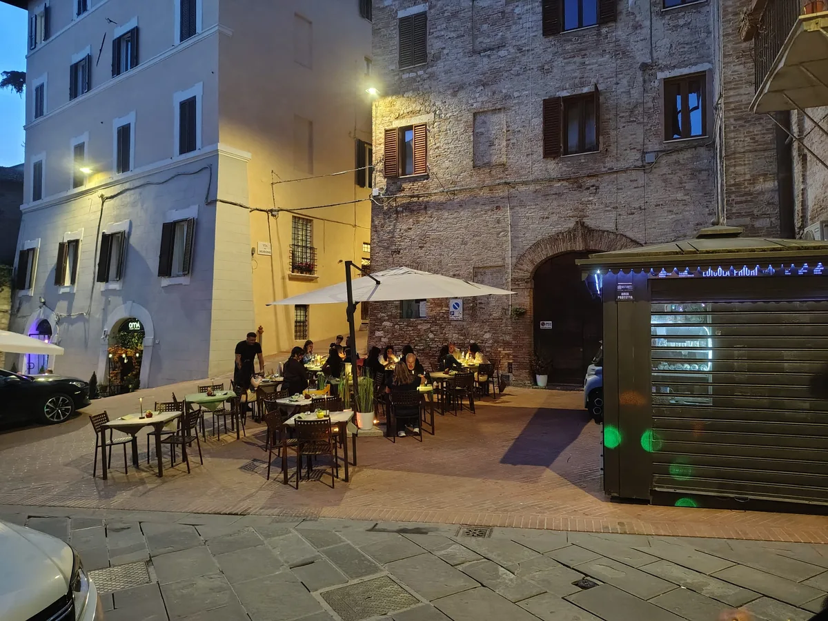 Terrazza serale della Grotta dei Priori — tavoli apparecchiati sotto le luci di Perugia