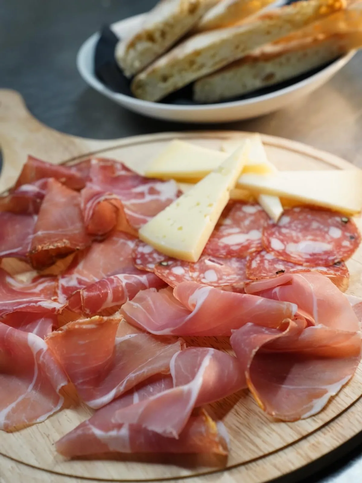 Tagliere di salumi e formaggi umbri con prosciutto, salame e pecorino su tagliere in legno