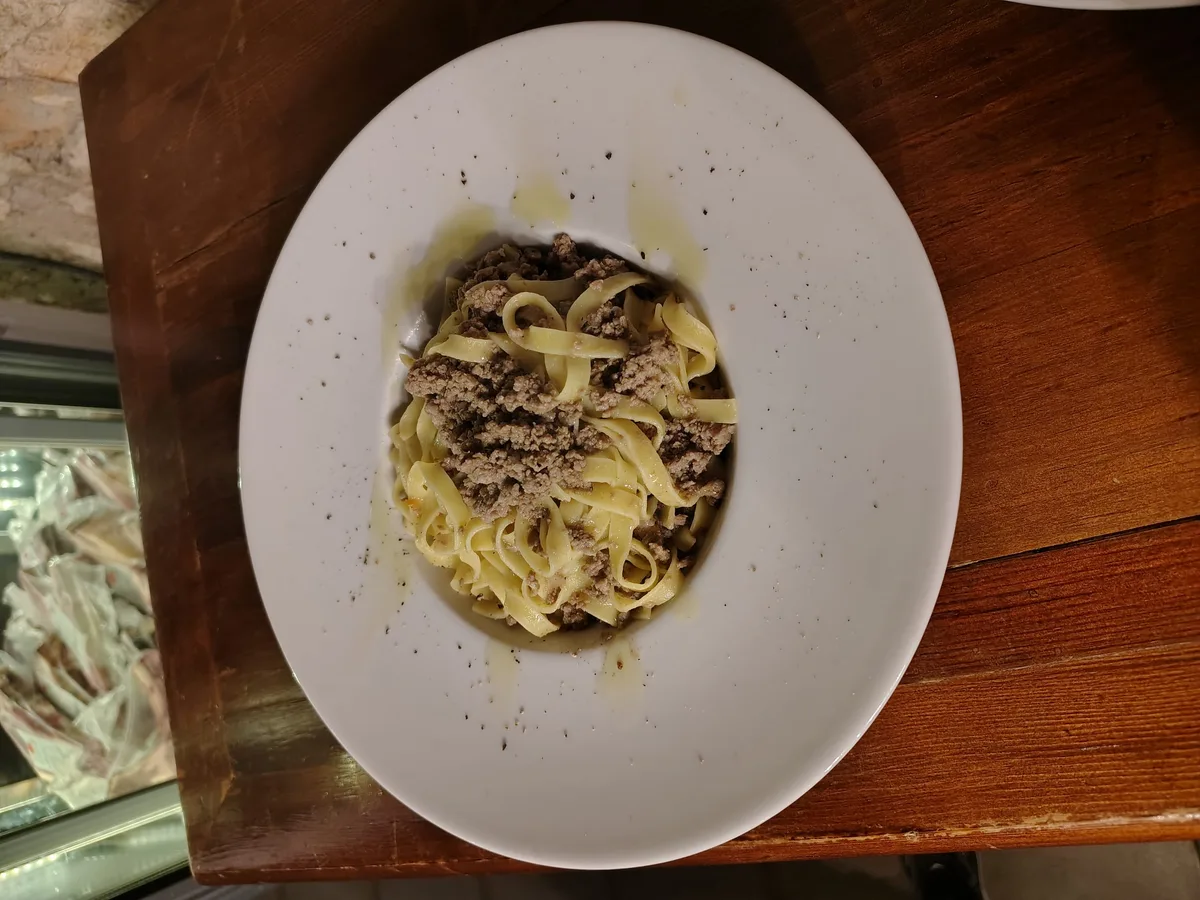 Tagliolini al tartufo nero di Norcia su piatto bianco ovale — specialità della casa
