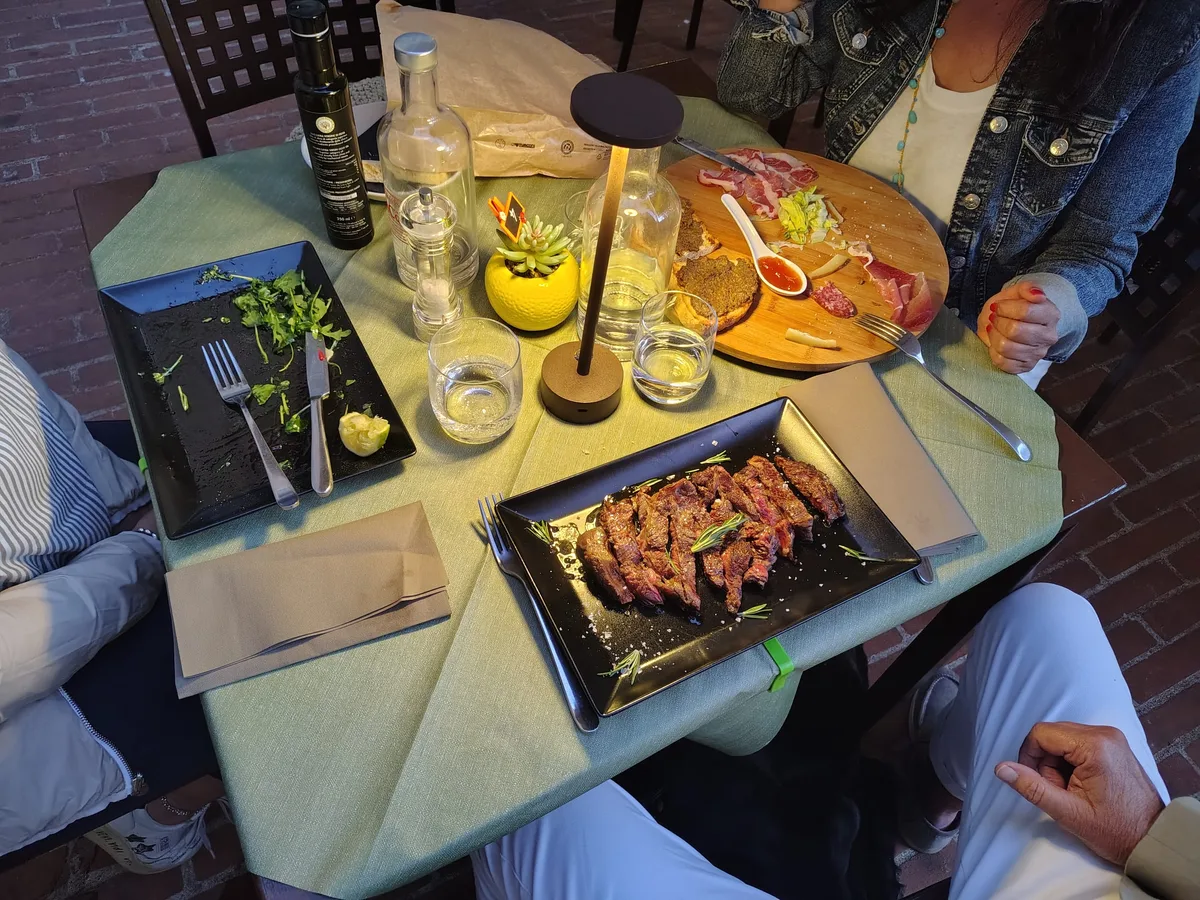 Tavolo serale alla Grotta dei Priori — lampada a led, tagliere e tagliata alla brace